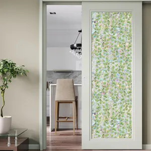 Decorative window film detail showing vibrant green leaf vine pattern on sliding glass door.