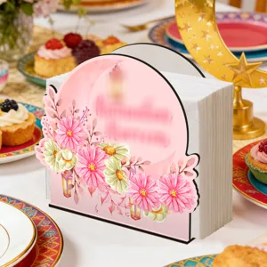 Gedetailleerde close-up van houten servettenhouder met roze bloemmotief op feestelijke tafel.