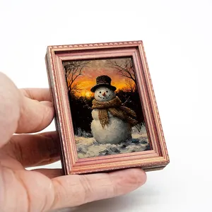 Gedetailleerd overzicht van de houten fotolijst magneet met schattig winters sneeuwpop schilderij.