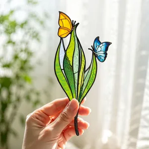 Insert de plante papillon en verre teinté et feuilles vertes, gros plan détaillé.