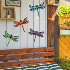 Colorful metal dragonfly wall art detail, vibrant painted hanging decor for garden and patio.