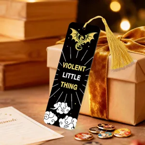 Detail view of a black acrylic bookmark with gold dragon motif and tassel, elegant reading accessory.