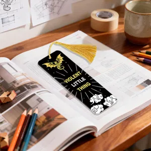 Acrylic bookmark with gold tassel, featuring dragon graphic and motivational quote for reading.