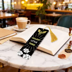 Detailed view of the black acrylic bookmark with gold tassel and dragon design for reading.
