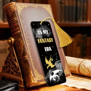 Detail shot of a black acrylic bookmark featuring dragon art, gold tassel and fantasy text.