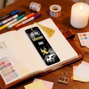 Detailed close-up of a creative black bookmark featuring a golden tassel and fantasy dragon pattern.