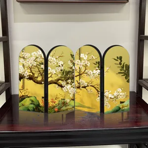Close-up of mini Chinese style folding screen ornament with gold mirror plum blossom design.