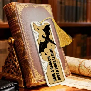 Close-up detail of creative acrylic bookmark with golden tassel and fantasy dragon design.