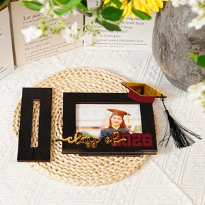 Dettaglio della cornice portafoto di laurea in legno con il testo e un mini cappello.