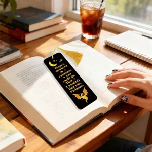 Black metal bookmark with gold quote and tassel, elegant reading accessory for book lovers.