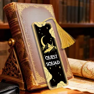 Close-up detail of black acrylic bookmark with gold tassel, moon and mountain night design.