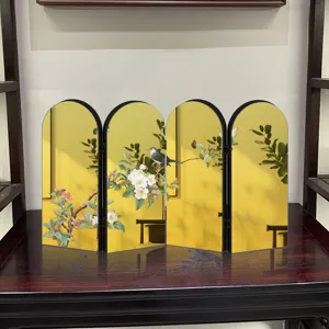 Close-up detail view of the golden Chinese style folding screen ornament on table display.