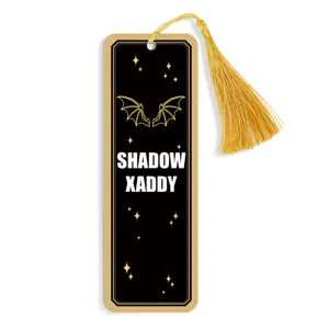 Gothic black and gold bookmark with golden tassel and bat wings design, perfect for readers.
