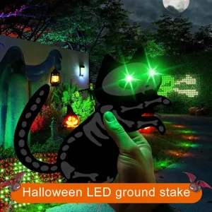 Halloween LED glowing green eyes black cat skeleton ground stake detail view in yard.