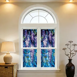 Detailscène van raamfolie met decoratief gebrandschilderd glas bloemenpatroon op binnenvensterglas.
