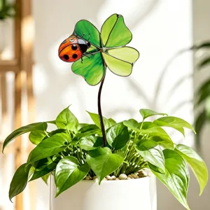 Vue en gros plan détaillée du trèfle en verre teinté et du tuteur de coccinelle pour plante.