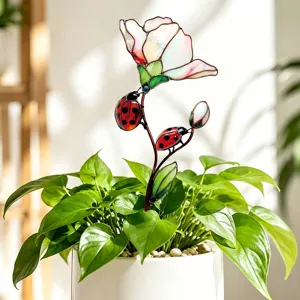 Gros plan détaillé d'un tuteur de plante en métal fleur et coccinelle style vitrail intérieur