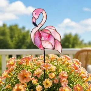 Gros plan d'un piquet de jardin en metal flamant rose colore dans un pot de fleurs pour deco exterieure.