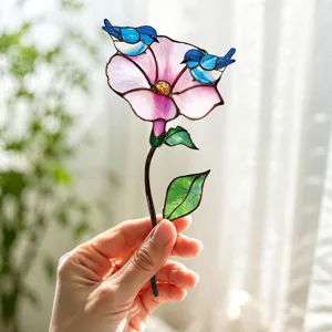 Vue détaillée d'une belle fleur en verre teinté artisanal avec de charmants oiseaux bleus.