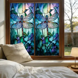 Gezellig slaapkamerraam detail met glas-in-lood libelle raamsticker in mooie blauwe tinten.