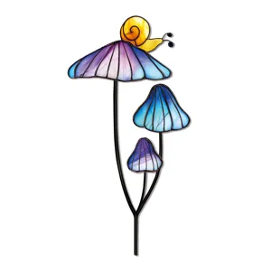 Gros plan détaillé d'un piquet de jardin champignon en verre coloré avec un joli petit escargot.