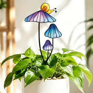 Vue détaillée de tuteurs de jardin colorés en verre avec champignons et escargot dans un pot.