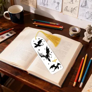 Detail shot of a stylish dragon pattern bookmark with golden tassel placed on open book desk.
