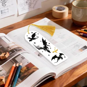Close up shot of dragon illustration acrylic bookmark with yellow tassel on open book.