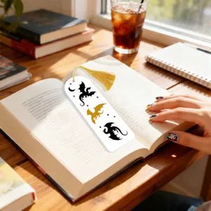 Detail view of creative translucent bookmark with dragon silhouette and gold tassel on open book.