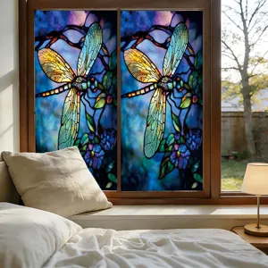 Detail van glasfolie in glas-in-loodstijl met kleurrijk libellen- en bloemenpatroon in de slaapkamer.