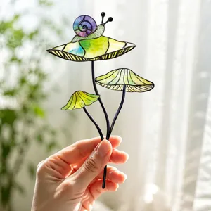 Vue en gros plan détaillée d'un tuteur de plante champignon et escargot en verre coloré.