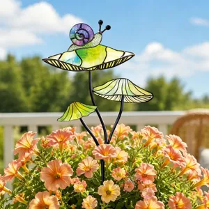 Détail de piquet de jardin en métal avec champignons colorés et escargot en pot déco.