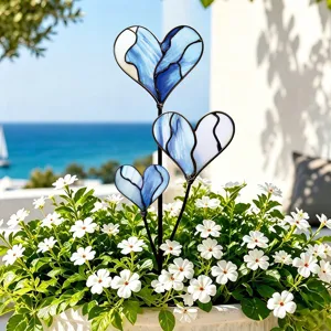 Vue détaillée de piques de jardin en verre bleu en forme de cœur pour plantes en pot.