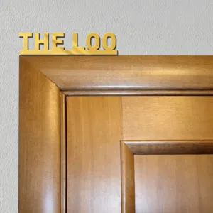 Close-up detail view of the luxury gold acrylic door sign mounted on the wooden frame.