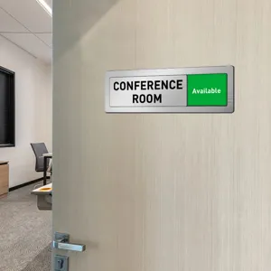 Conference room sliding door status sign detail view with metal brushed frame and green slider.