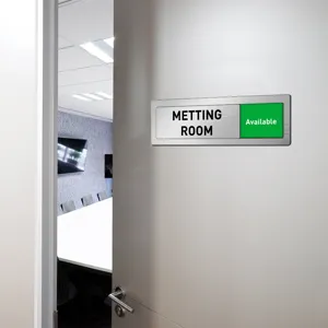 Close-up of sliding office door sign with metal finish and green available status indicator.
