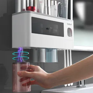 Wall-mounted toothbrush holder with automatic toothpaste dispenser and inverted magnetic cups.