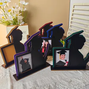Primo piano di un supporto per cornice portafoto di laurea in legno con sagoma di laureato e fessura.