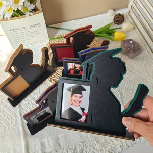 Dettaglio della cornice portafoto di laurea in legno con supporto sagomato colorato.