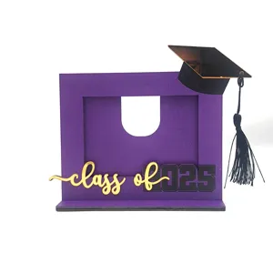 Dettaglio cornice portafoto di laurea, decoro in legno viola con berretto 2025.