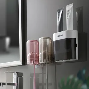 Soportes de cepillo de dientes de pared con dispensador automático de pasta y tazas para el baño.