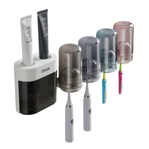 Soporte de cepillo de dientes de pared con dispensador automático de pasta de dientes y tazas invertidas.