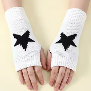 Detail shot of winter knitted fingerless gloves with black star pattern on white fabric.