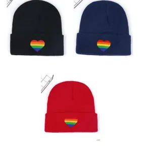 Detalle de primer plano de gorro de punto de invierno con bordado de corazón arcoíris.
