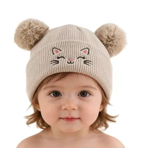 Joli bonnet tricoté pour bébé avec broderie chat et deux pompons pour un hiver chaud.