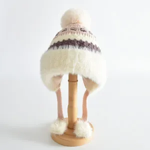 Détail en gros plan du bonnet tricoté chaud pour enfants avec doublure douce et pompon duveteux.