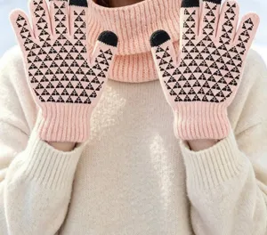 Guantes de punto táctiles rosas con patrón de triángulos negros para manos abrigadas.