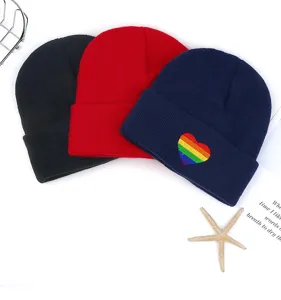 Detalle gorro de punto, diseño de bordado de corazón arco iris colorido, primer plano gorro.