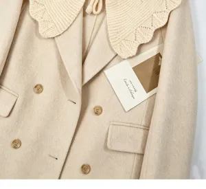 Detaillierter beigefarbener Wollmantel mit Strickkragen und zweireihigen Knöpfen.