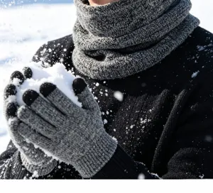 Vue detaille de l'ensemble gants et echarpe en tricot gris avec texture chaude dans la neige.